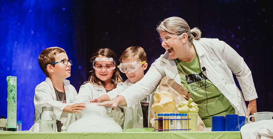 Jennifer "Jupiter Jen" Moorhead guides two elementary school students in a Science Explorers assembly